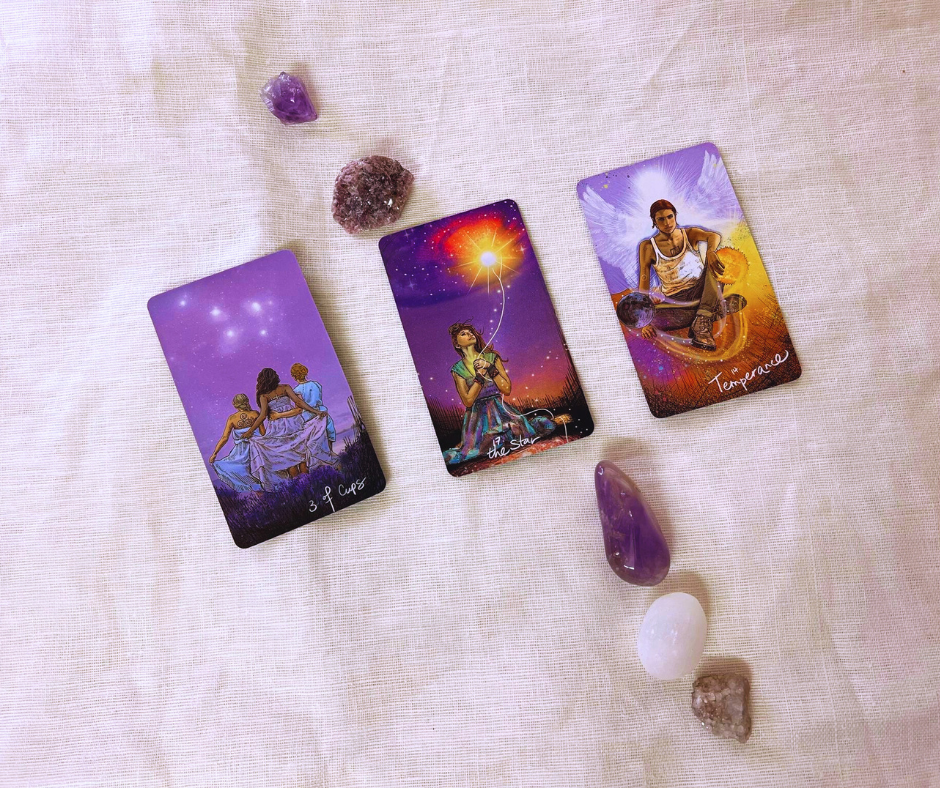 photo of 3 tarot cards surrounded by crystals